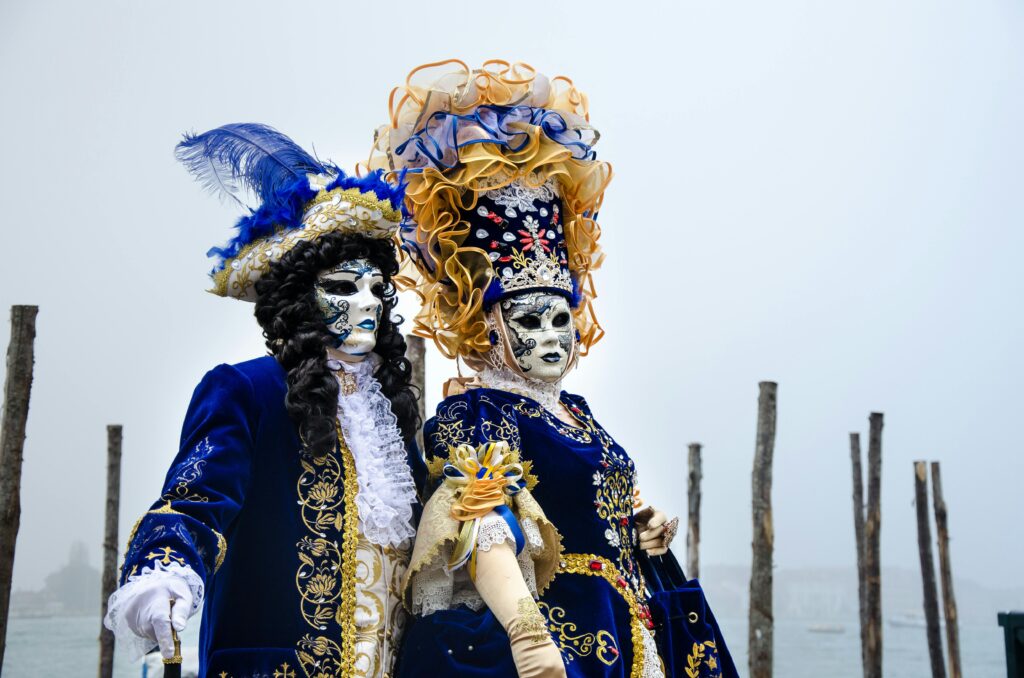 pexels-photo-9980470-9980470 Couple in elaborate Venetian costumes at a traditional masquerade event, showcasing exquisite craftsmanship.